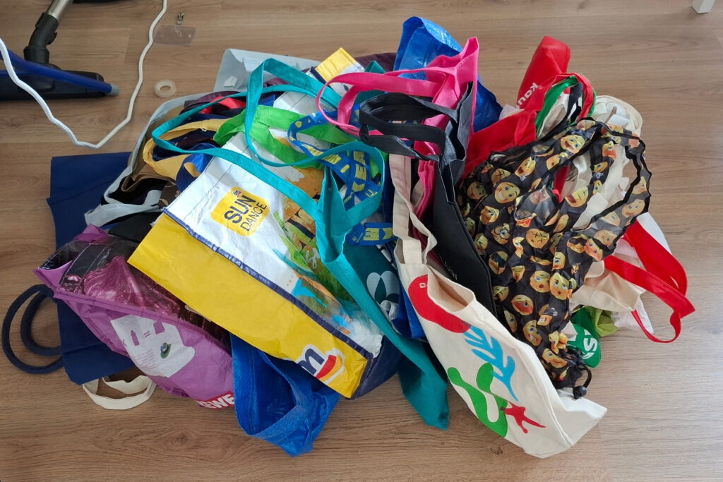 Ausmisten: von 32 Tüten und Taschen wurden 25 aussortiert. 32 Tüten und Taschen liegen auf einem Berg. Davon wurden 25 aussortiert.