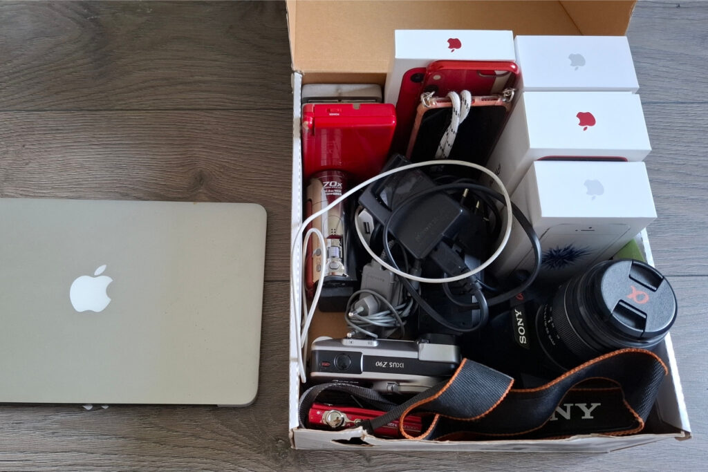 Aussortierte Geräte, die noch etwas mehr wert sind, möchte meine Kundin verkaufen. Eine Sammlung aus Smartphones und Kameras sowie ein Laptop: Aussortierte Geräte, die noch etwas mehr wert sind, möchte meine Kundin verkaufen.